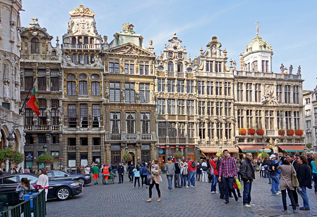 Gilded guild houses and a Gothic town hall tower around a cobbled square