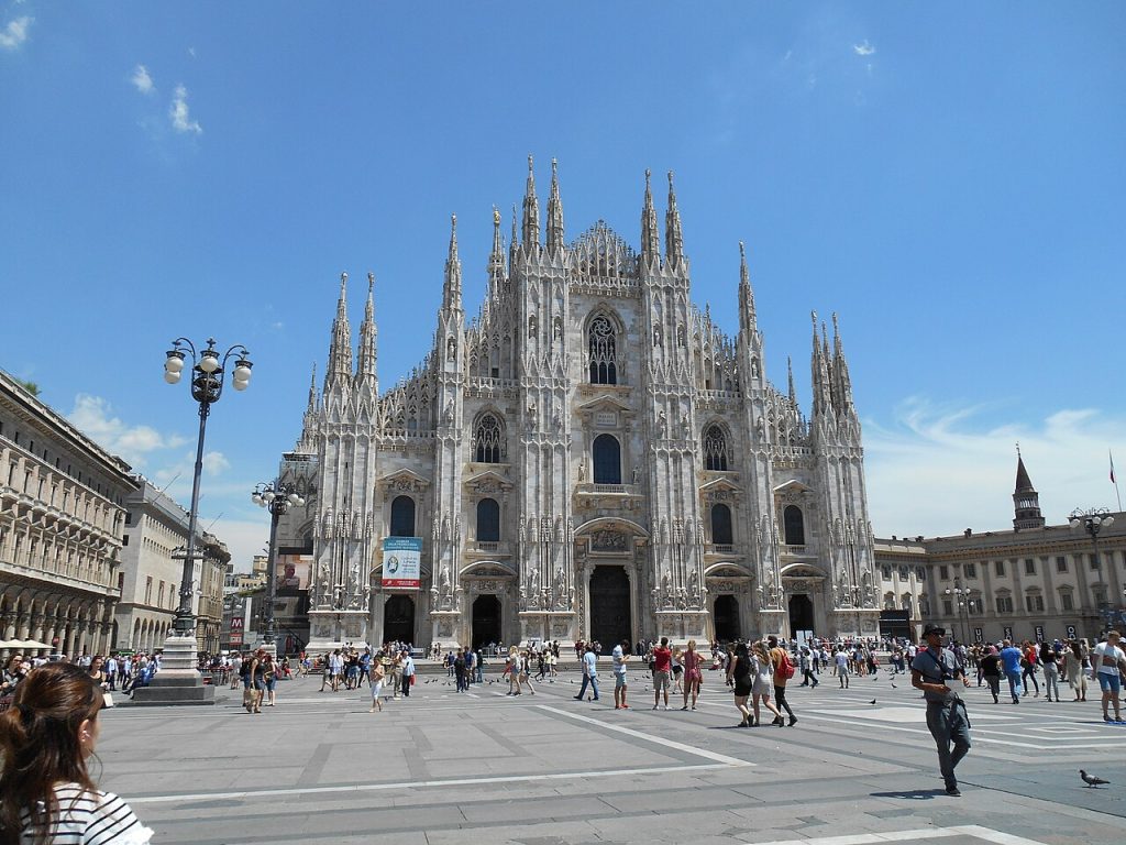 The white marble facade of Milan Cathedral covered in spires and statues