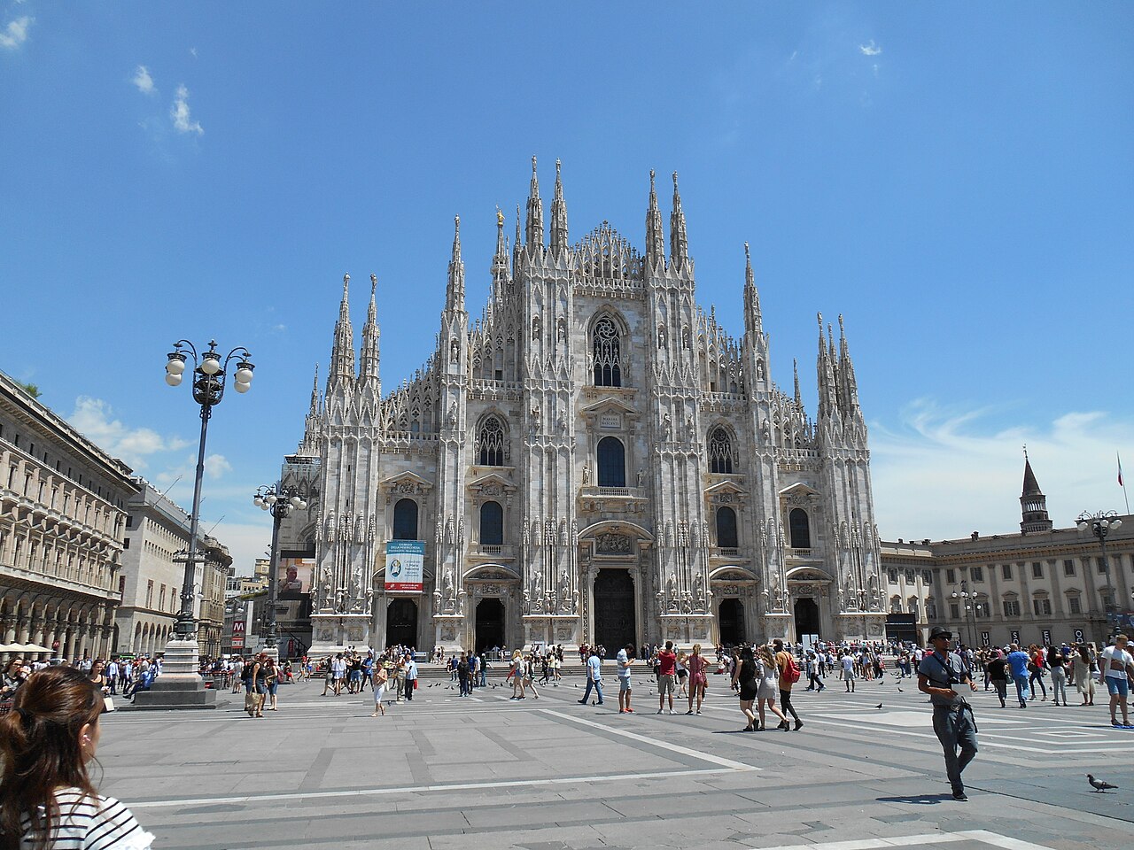 The white marble facade of Milan Cathedral covered in spires and statues