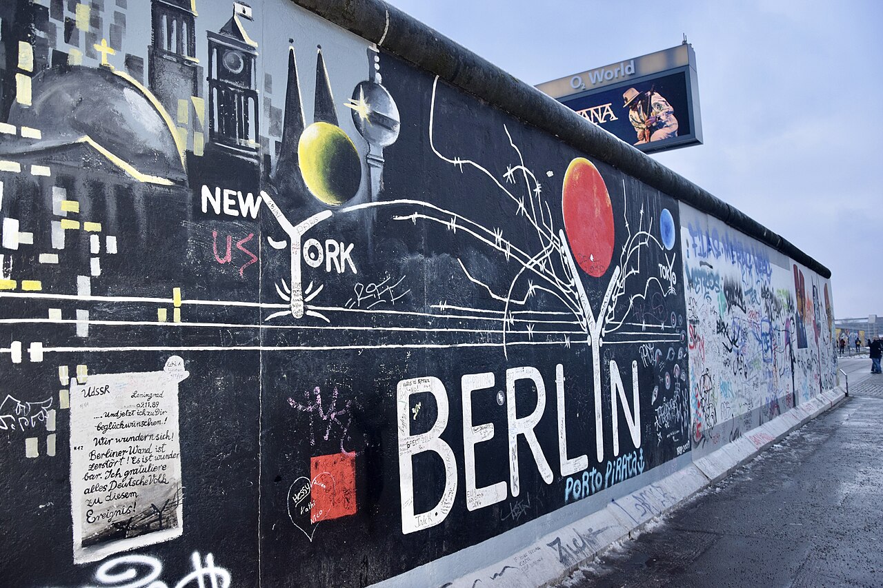 Painted panels on a surviving stretch of the Berlin Wall at the East Side Gallery, beside the road