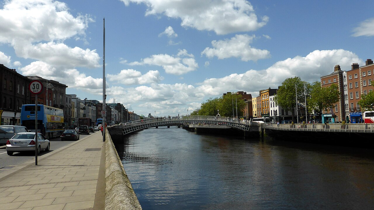 The cast-iron Ha'penny Bridge arching over the River Liffey with quayside buildings behind