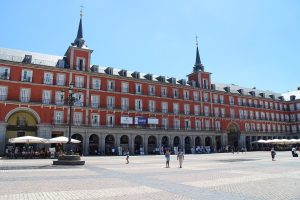 The arcaded facades of the Plaza Mayor with the frescoed Casa de la Panaderia at the far side