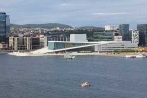 A white marble opera house sloping into the fjord with people walking on its roof