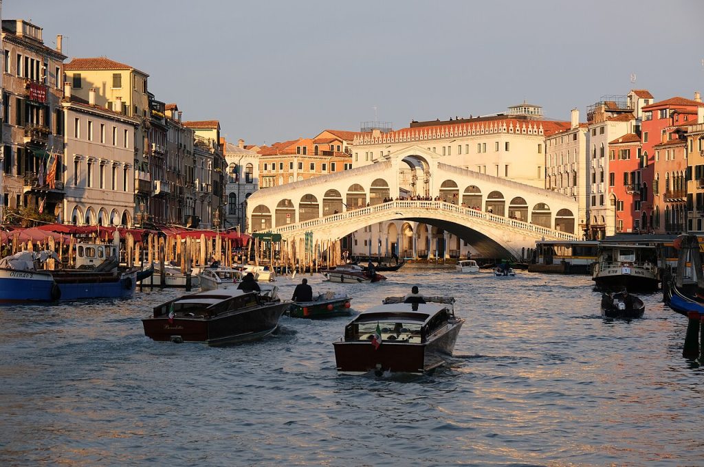 The stone arch of the Rialto Bridge over the Grand Canal, lined with shops