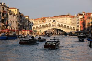 The stone arch of the Rialto Bridge over the Grand Canal, lined with shops