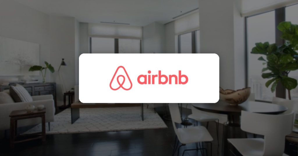 Airbnb logo over a bright apartment living room