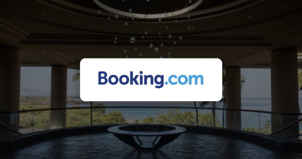 Booking.com logo over a hotel lobby with an ocean view