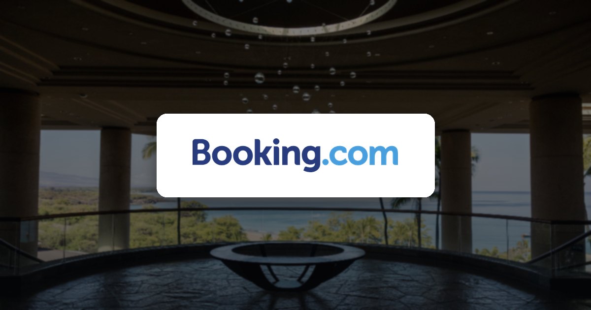 Booking.com logo over a hotel lobby with an ocean view