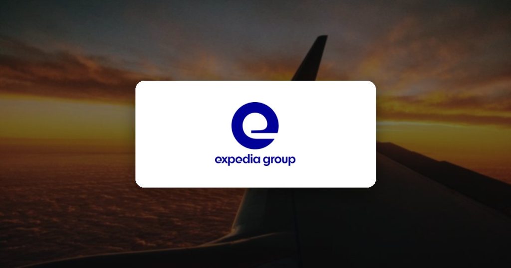 Expedia Group logo over an airplane wing at sunset